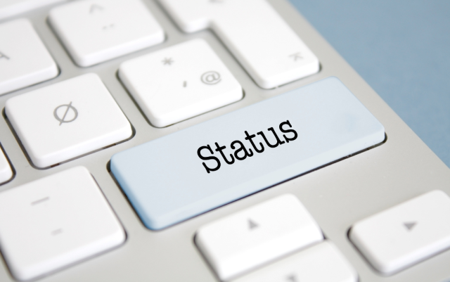 Photo closeup of a keyboard with a Status key. The other keys are indistinct.